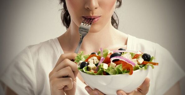 Dívka drží talíř salátu