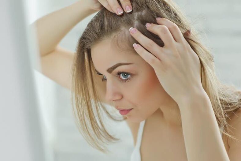 Dívka zkoumá ložiska alopecie